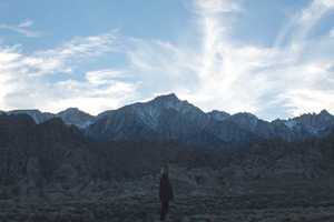 A young, college age free spirit looking over rocky hills and then Mt. Whitney in the distance.