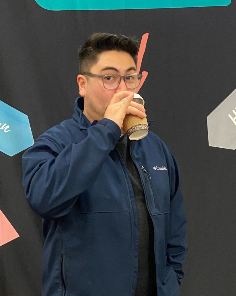 Matthew sipping coffee in front of a screen