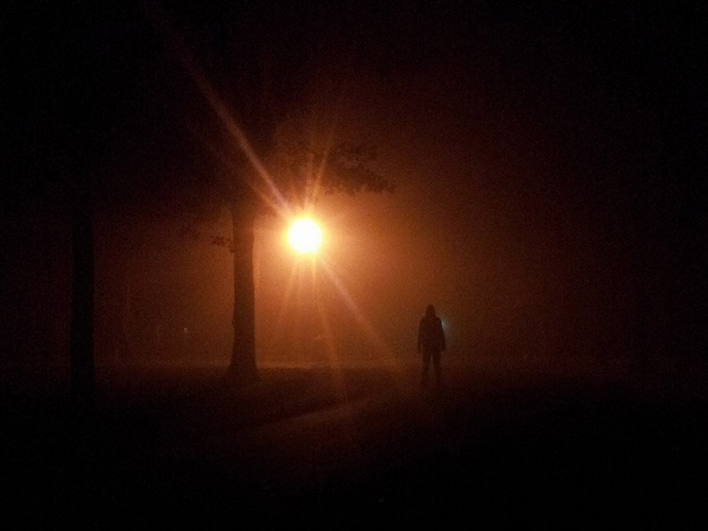 siloughetted figure under solitary orange light