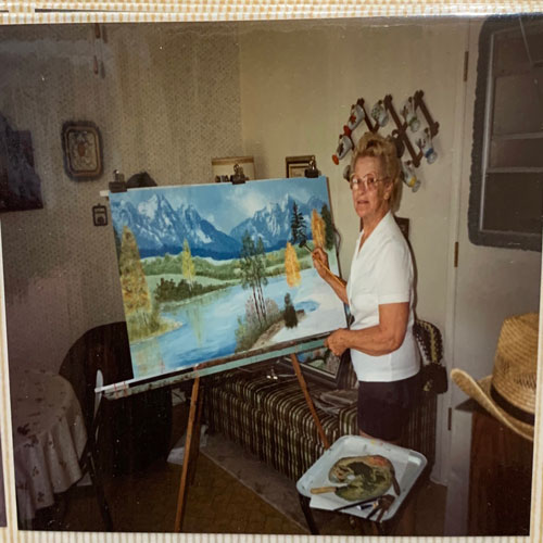This image is of a lady painting on a canvas.