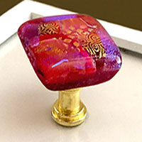 Picture of Red knob on Gold base on drawer front.