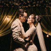 A newly wed couple dance close in the evening