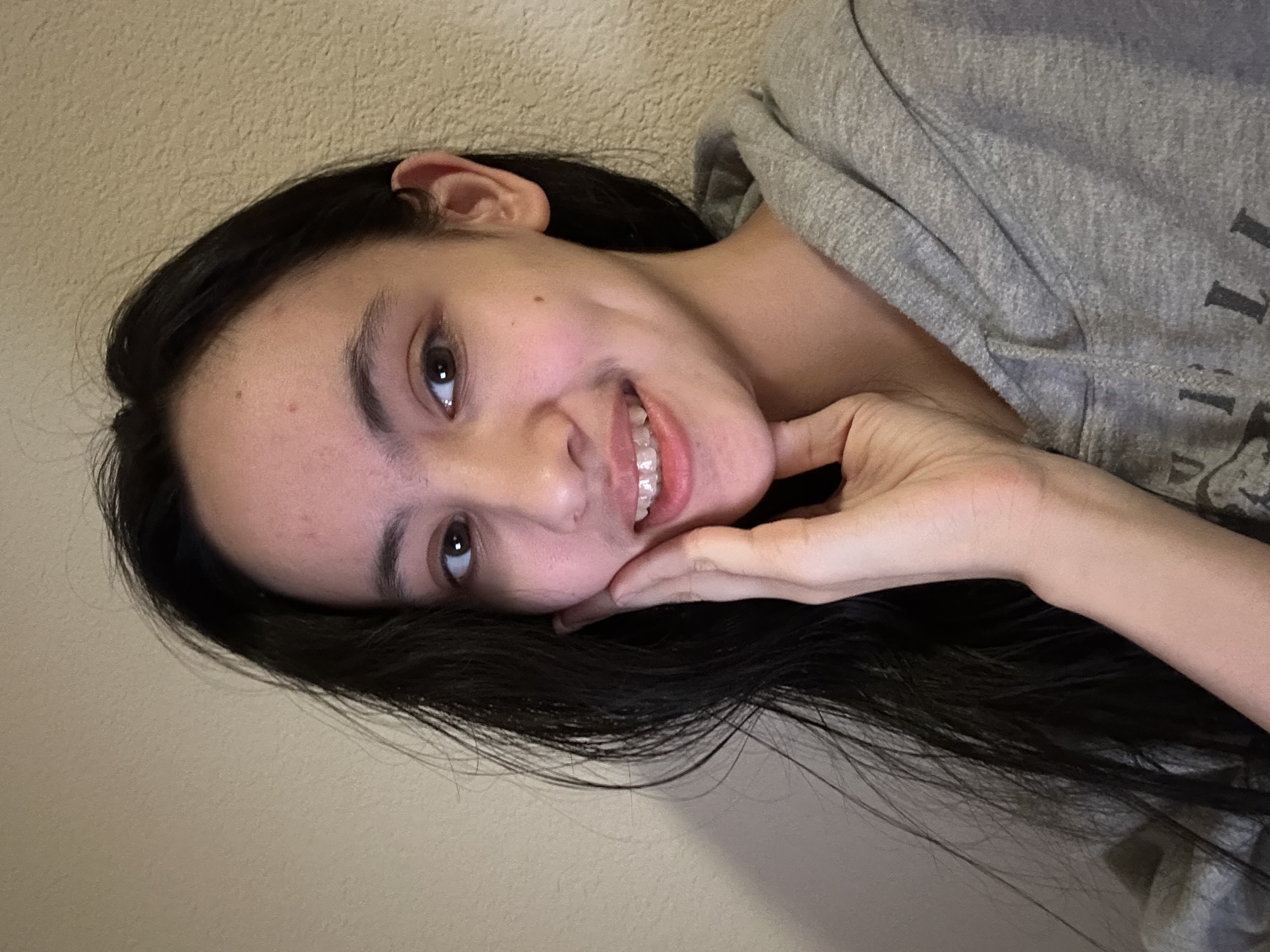 An image of myself in hoodie, smiling and pressing a hand to my face.