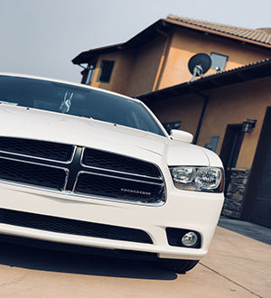 Dodge Charger stanced in front of modern mansion
