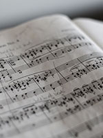 Closeup picture of printed music notaton with handwritten notes in a book.