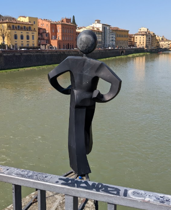 A statue of a the person symbol stepping off a bridge into a river.