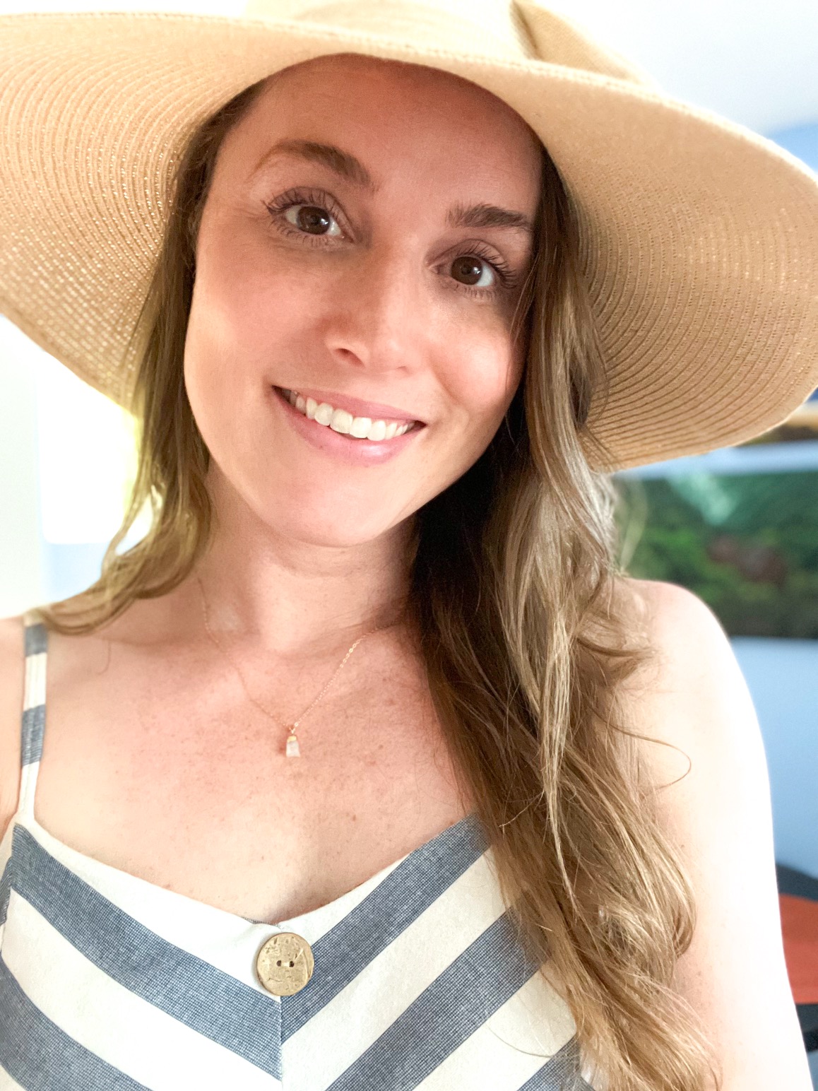 picture of woman with sun hat and blue striped dress