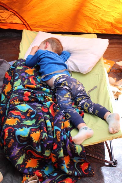 boy sleeping in his portable cot