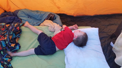 boy sleeping in his portable cot