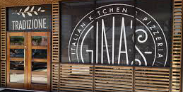 white decal signage on a store front window advertising Gina's italian pizzeria in a circular logo
